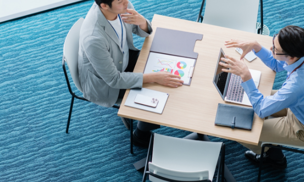 PCを使用して会議をする2人の男性の画像